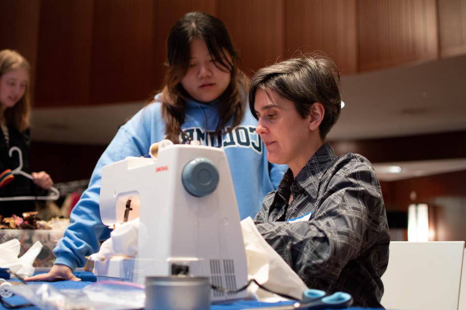 Professor demonstrates clothing repair at 2019 Women, Clothing, Climate event